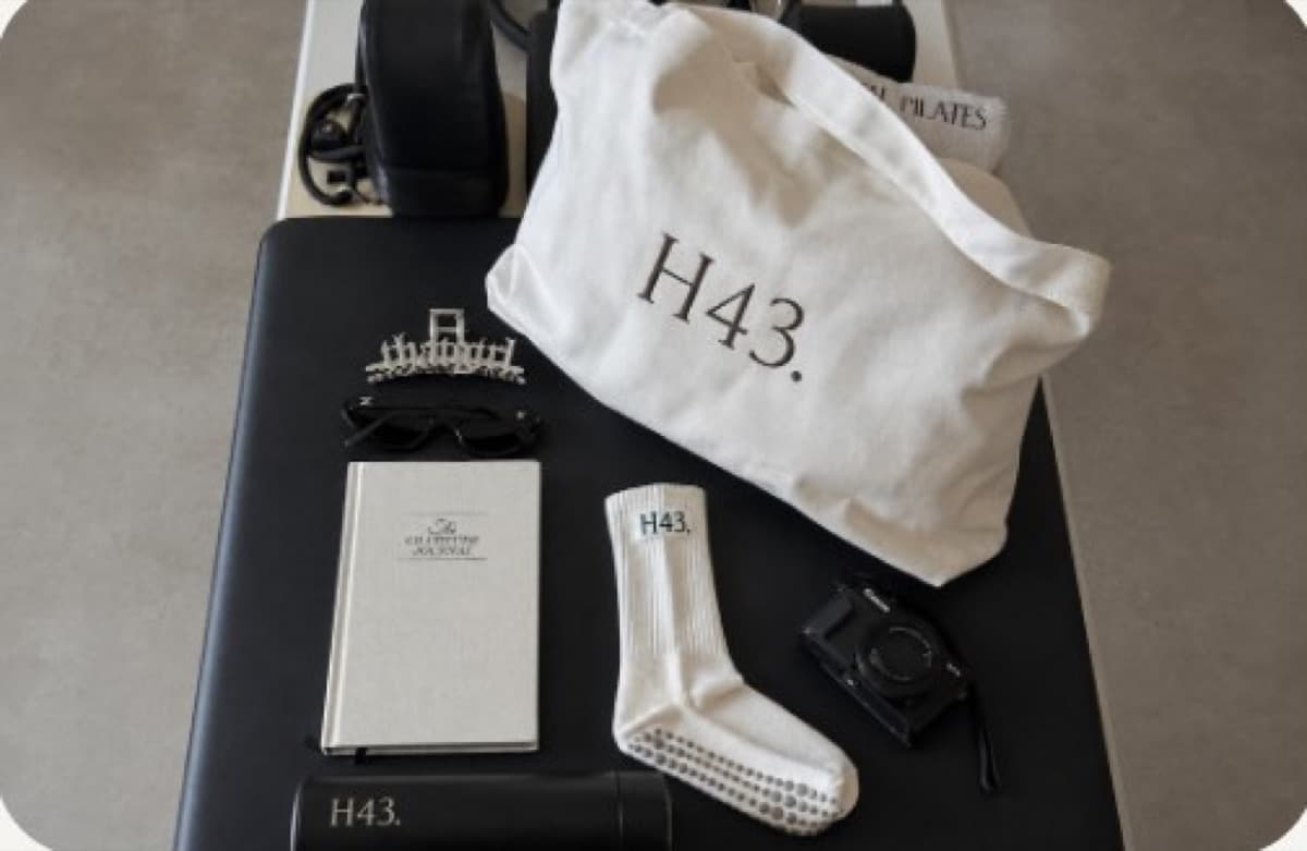 H43 tote bag, crew sock and branded accessories laid out on a studio floor