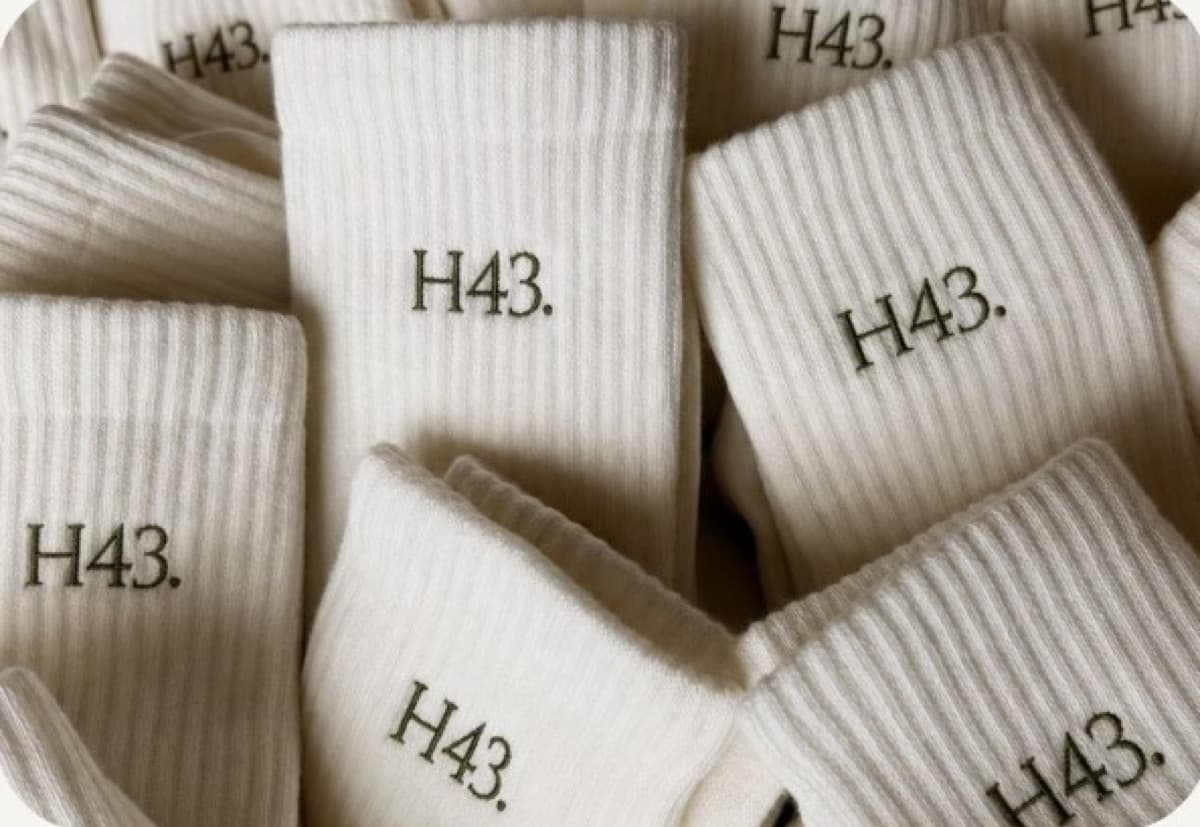 Pile of cream grip socks with H43 embroidered on the cuffs